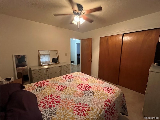 bedroom with carpet floors, a textured ceiling, ceiling fan, and a closet