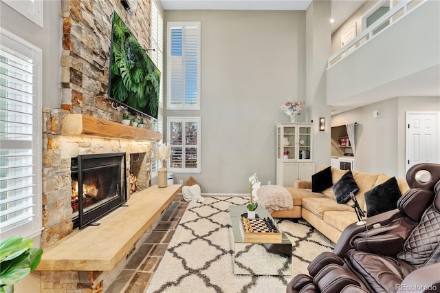 living area with a high ceiling and a fireplace