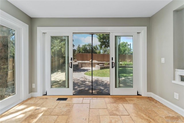 entryway featuring baseboards, visible vents, and stone tile floors