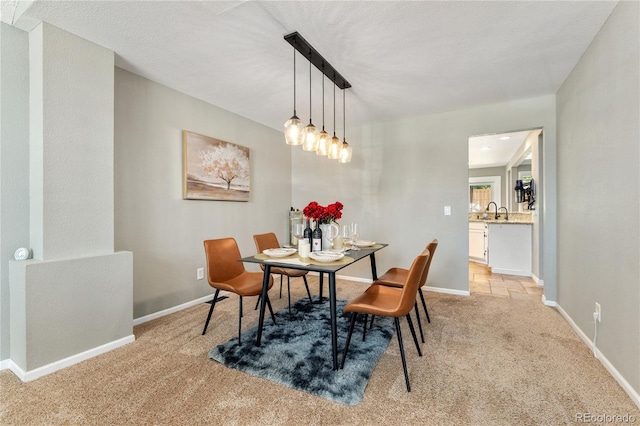 dining room featuring baseboards and light colored carpet