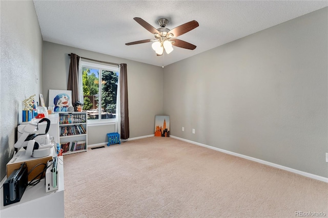 rec room featuring visible vents, baseboards, a ceiling fan, a textured ceiling, and carpet flooring