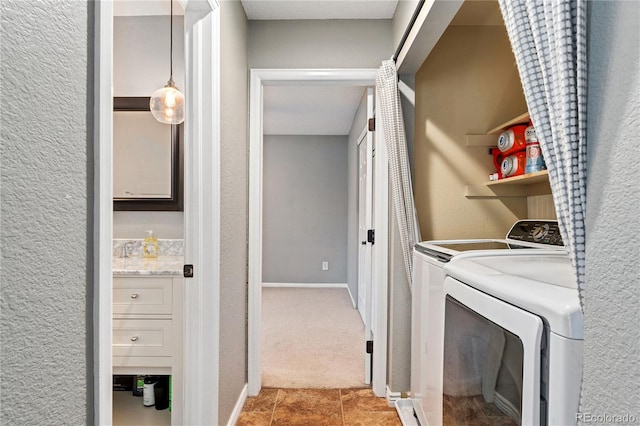 laundry area with a textured wall, light carpet, washer and dryer, laundry area, and baseboards