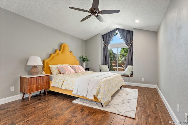 bedroom featuring dark wood finished floors, lofted ceiling, a ceiling fan, a textured ceiling, and baseboards