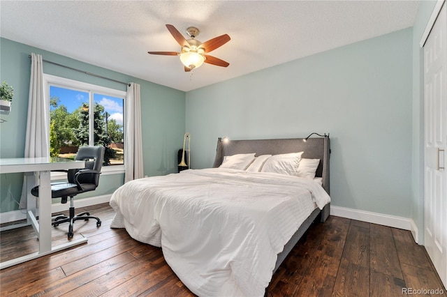 bedroom with dark wood-style flooring, a closet, and baseboards