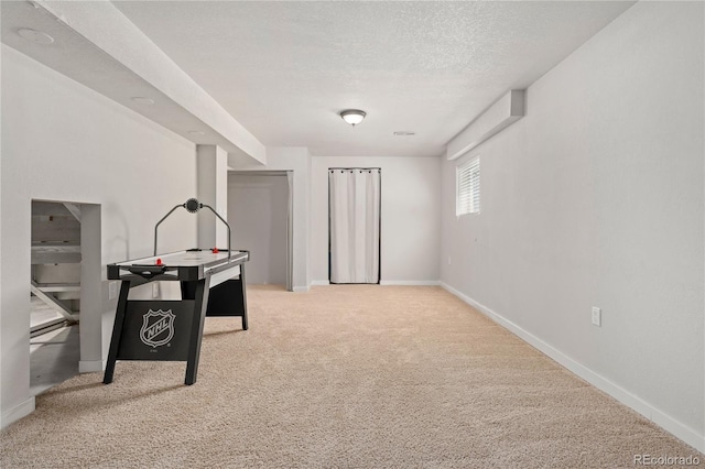 game room with carpet floors, a textured ceiling, and baseboards