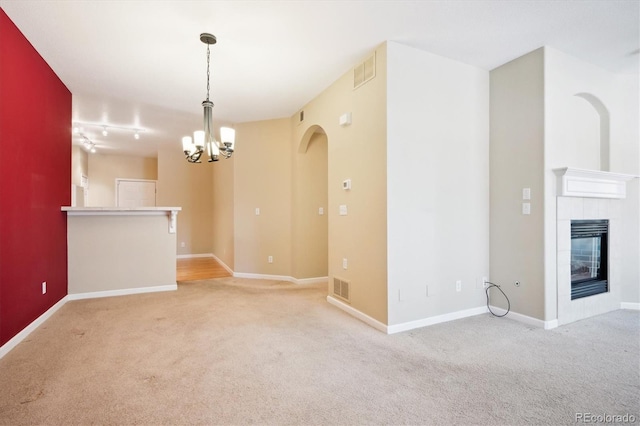 interior space featuring a tiled fireplace and an inviting chandelier