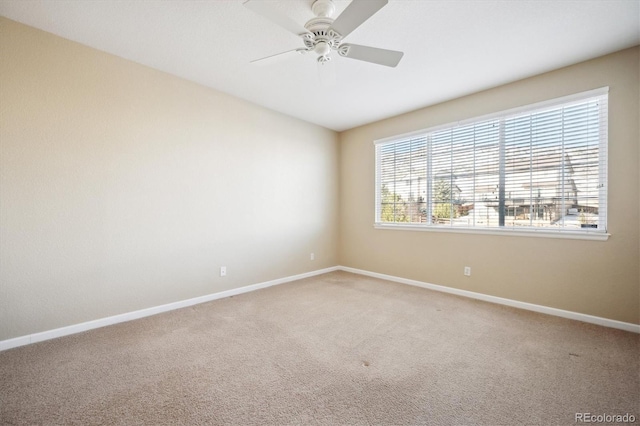 carpeted spare room with ceiling fan