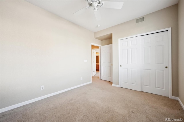 unfurnished bedroom featuring light carpet, ceiling fan, and a closet