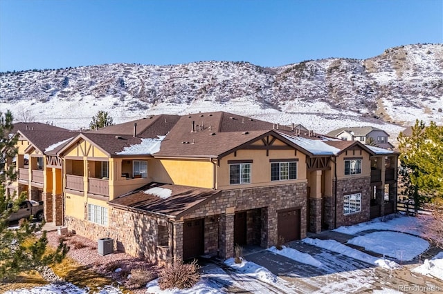 view of front of home featuring a garage, a mountain view, and central air condition unit