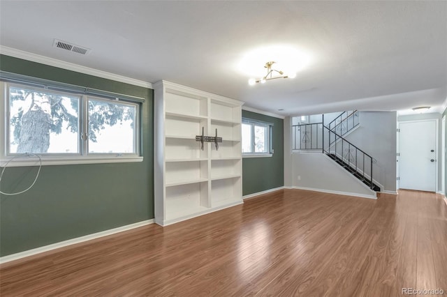 spare room with ornamental molding, stairway, wood finished floors, and baseboards