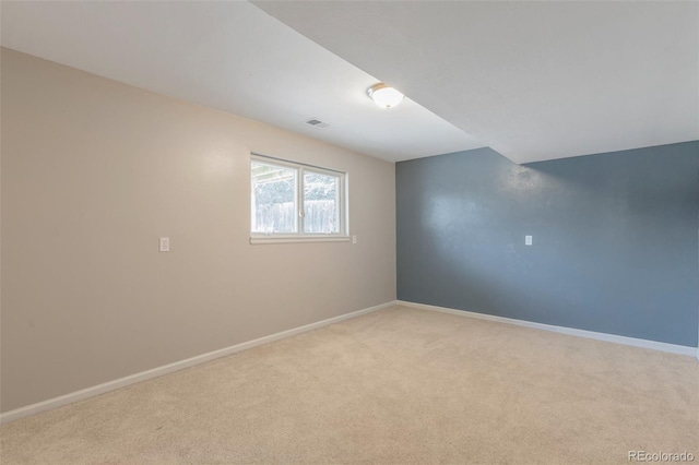 empty room featuring visible vents, baseboards, and light colored carpet