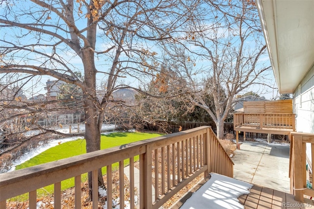 wooden terrace with a yard and fence