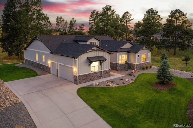 view of front of house featuring stone siding, board and batten siding, a garage, concrete driveway, and a lawn