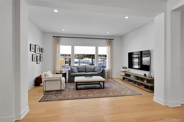 living area with wood finished floors, recessed lighting, and baseboards