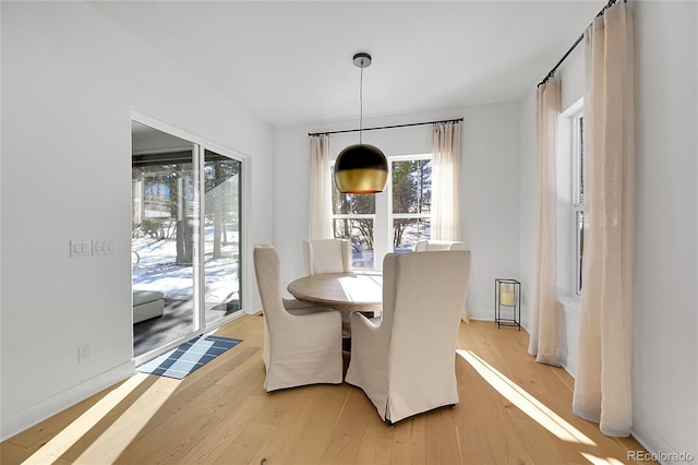 dining room featuring light wood-style flooring and baseboards