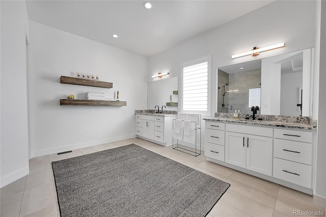 full bathroom featuring tile patterned floors, a shower stall, two vanities, baseboards, and recessed lighting