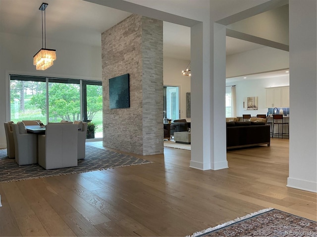 9228 Lone Timber Ct, Parker, CO 80134 - dining space featuring a chandelier, light wood-style floors, a towering ceiling, and plenty of natural light