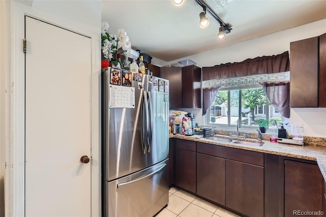 1958 Cathay Ct, Aurora, CO 80011 - kitchen with freestanding refrigerator, a sink, dark brown cabinetry, and light tile patterned floors
