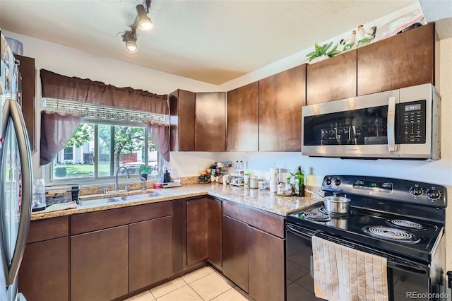 1958 Cathay Ct, Aurora, CO 80011 - kitchen with stainless steel appliances, light tile patterned floors, a sink, light stone countertops, and a textured ceiling