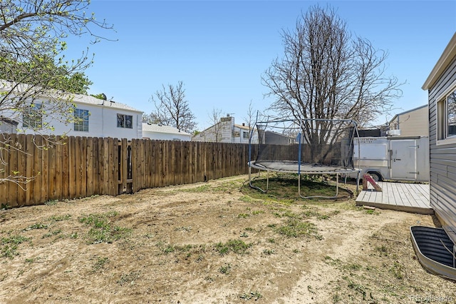 1958 Cathay Ct, Aurora, CO 80011 - fenced backyard featuring a trampoline and a wooden deck