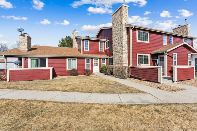 view of front of house with a chimney and a front yard