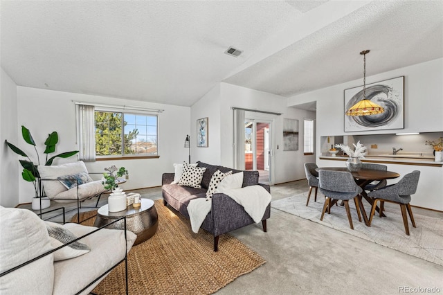 living room featuring light carpet, visible vents, and a textured ceiling