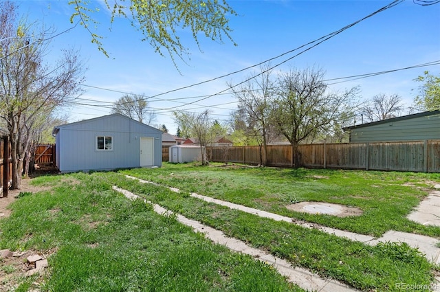 view of yard featuring an outbuilding, a shed, and a fenced backyard