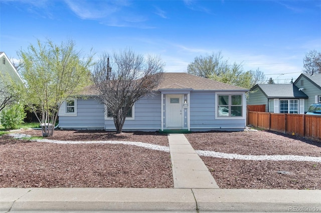 view of front of property with fence and a shingled roof
