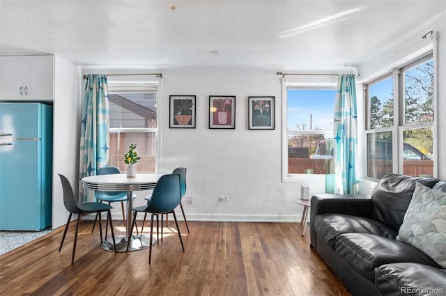 dining area with hardwood / wood-style flooring and baseboards