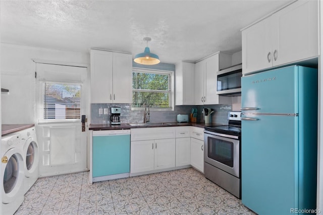kitchen featuring washing machine and clothes dryer, tasteful backsplash, a sink, white cabinets, and appliances with stainless steel finishes