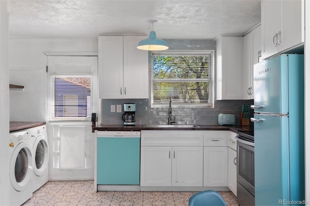 kitchen with a sink, separate washer and dryer, stainless steel range with electric cooktop, dishwashing machine, and freestanding refrigerator
