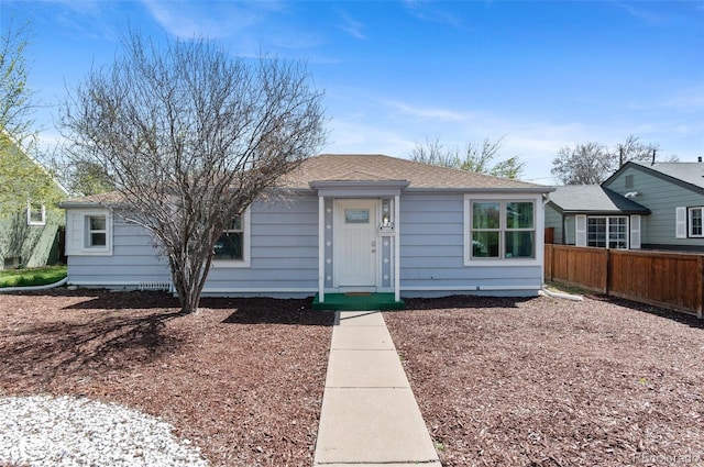view of front of home featuring fence and roof with shingles