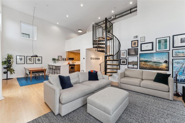 living room featuring a high ceiling and light wood-type flooring