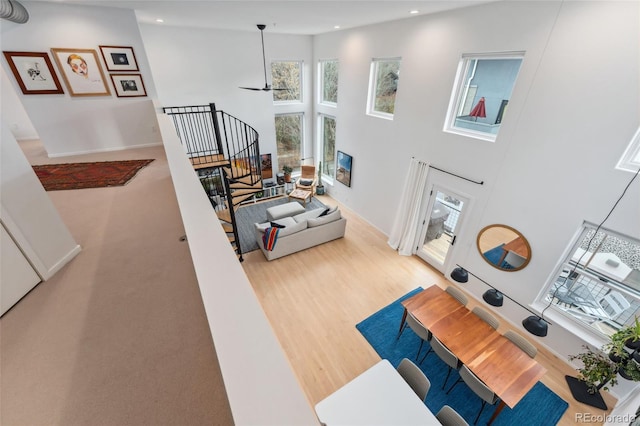 living room featuring a high ceiling, hardwood / wood-style flooring, and ceiling fan