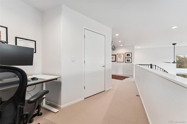 carpeted home office featuring ceiling fan