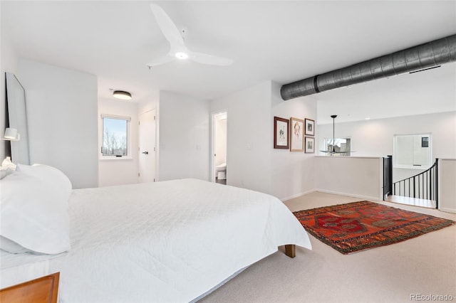 bedroom with ceiling fan, ensuite bathroom, and carpet flooring