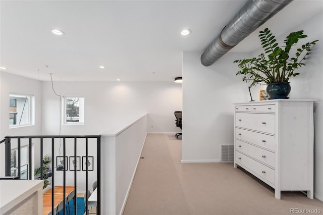 hall featuring light colored carpet