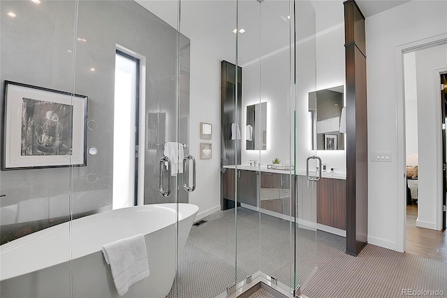 bathroom with independent shower and bath, vanity, and hardwood / wood-style flooring