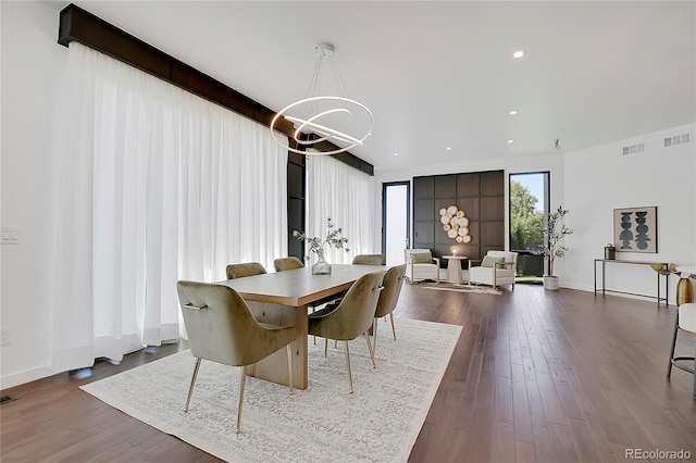 dining space with an inviting chandelier and hardwood / wood-style flooring