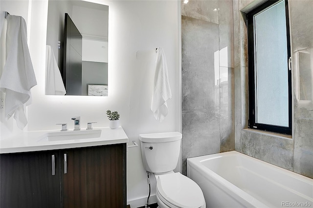 bathroom featuring vanity, a tub to relax in, toilet, and a healthy amount of sunlight