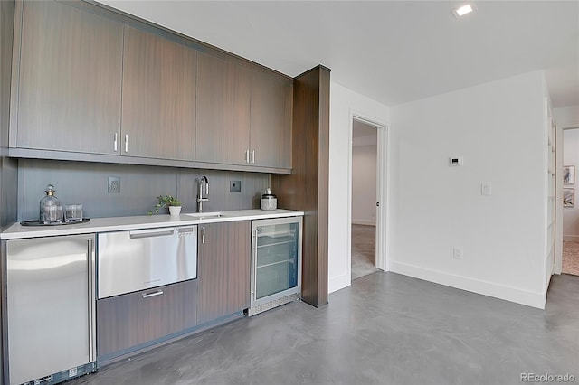 kitchen with wine cooler, sink, and concrete floors