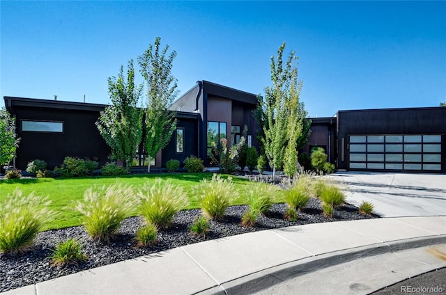 modern home featuring a front yard and a garage