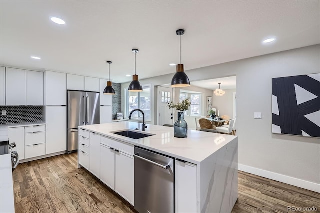 kitchen featuring sink, an island with sink, white cabinets, and appliances with stainless steel finishes