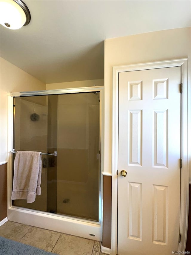 full bathroom with a stall shower and tile patterned floors