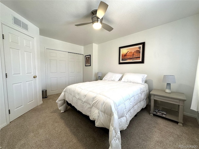 bedroom featuring a closet, carpet flooring, a textured ceiling, a ceiling fan, and visible vents