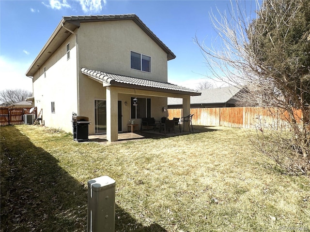 back of property featuring a patio area, stucco siding, a fenced backyard, and a yard