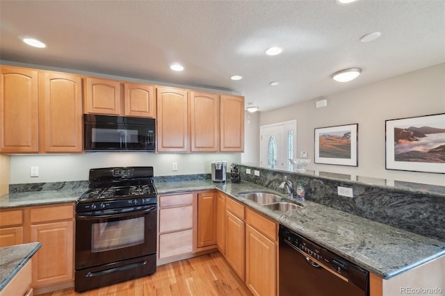 6701 W Yale Ave, Lakewood, CO 80227 - kitchen with black appliances, a sink, light brown cabinets, light wood finished floors, and stone counters
