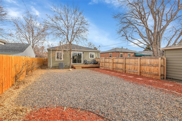 back of property featuring a wooden deck, an outdoor structure, and central AC