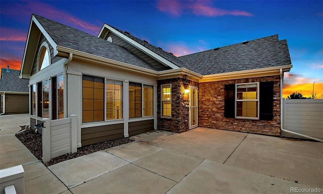 back house at dusk with a patio area