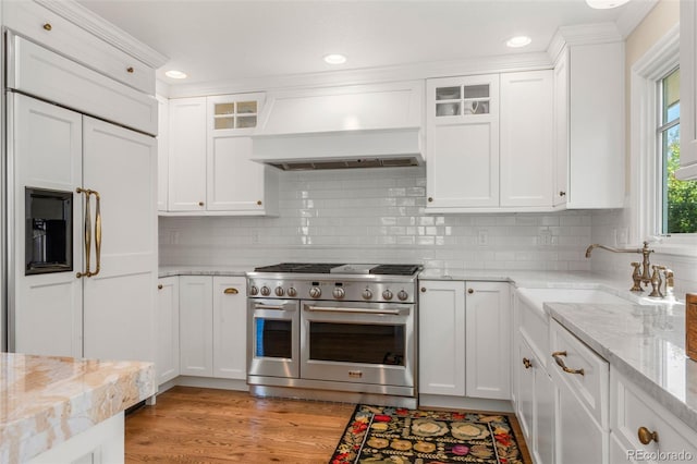 10 Oakmont Ln, Littleton, CO 80127 - kitchen with premium appliances, custom range hood, white cabinetry, light wood-style floors, and recessed lighting